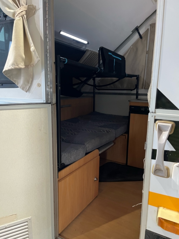 Side-on view of the Spinifex bunk fitted over the bench bed through the door
