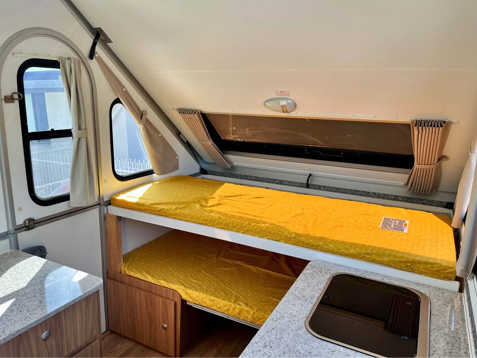 Factory built-in timber bunk beds in an Avan with yellow mattresses