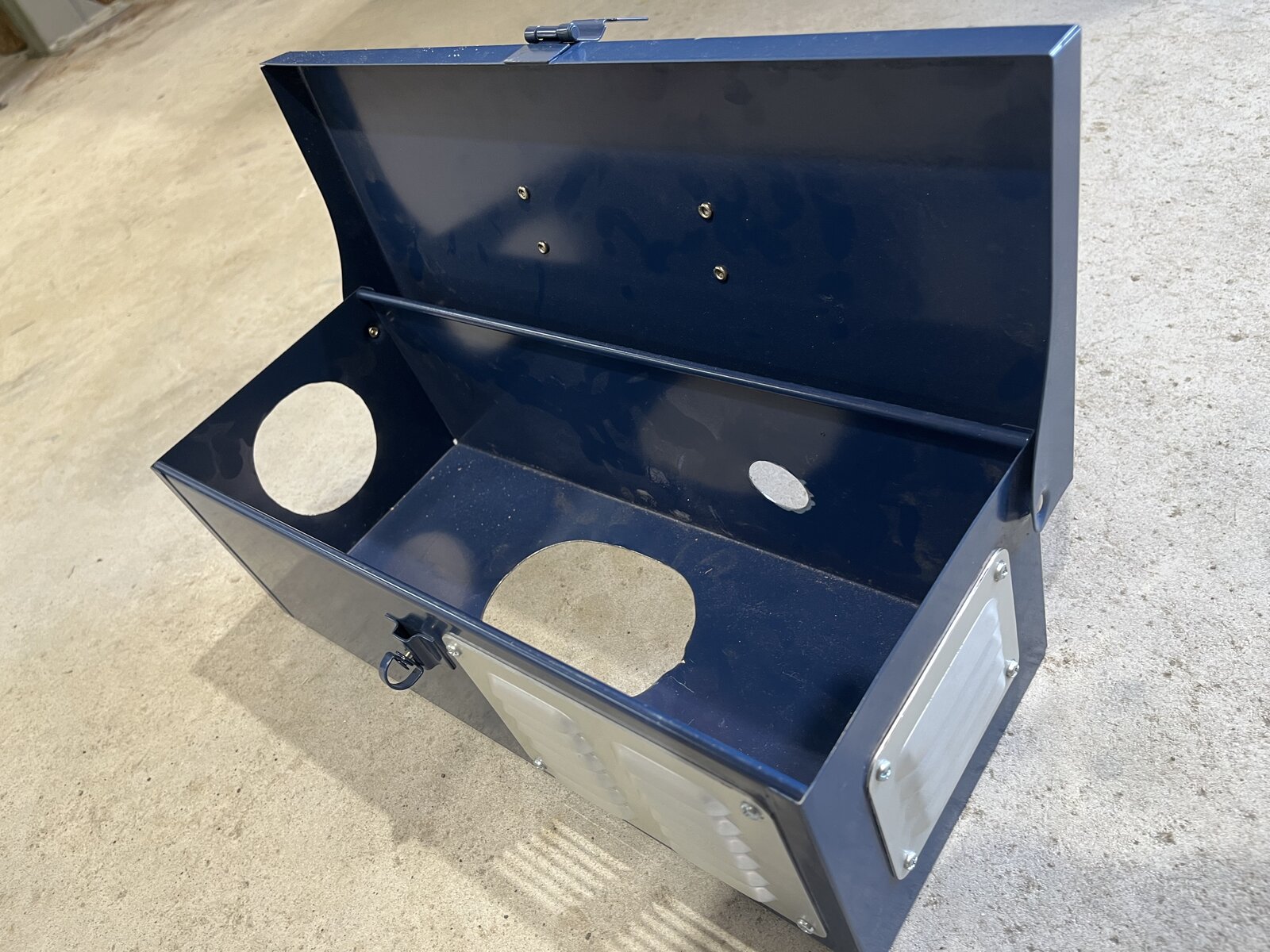 Blue steel toolbox with three circular cutouts for combustion air, exhaust and outlet hoses