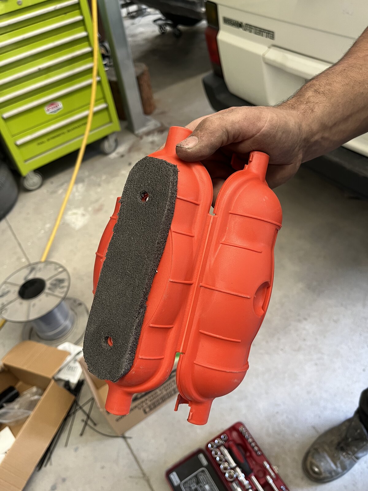Orange combustion air filter housing open showing foam filter element inside