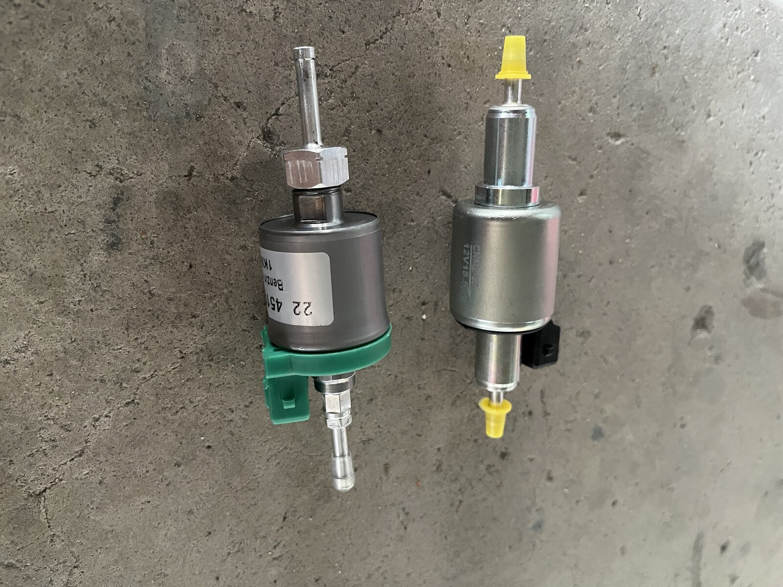 Original supplied fuel pump (green connector) beside higher-quality replacement (yellow cap)