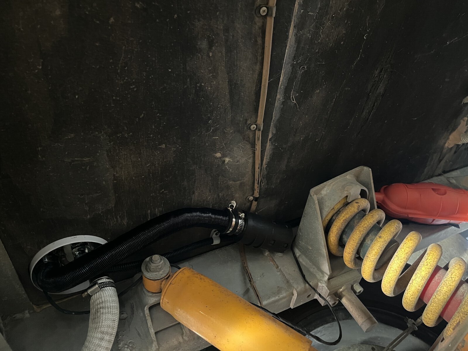 Corrugated combustion air intake hose routed through floor and clamped to chassis
