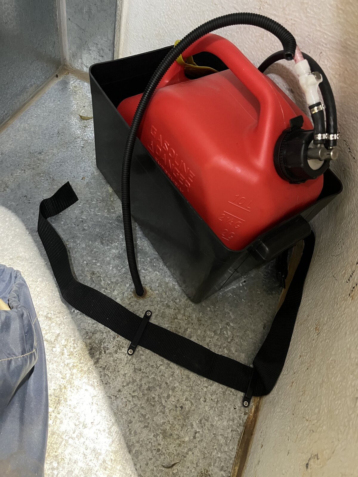 10-litre red jerry can in steel mounting box with fuel pickup fitting and nylon strap anchor